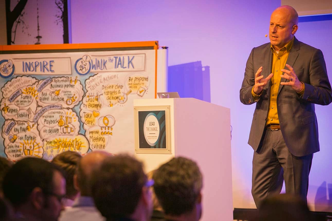 Ramon Vullings speaking beside hand-drawn visual notes at an event